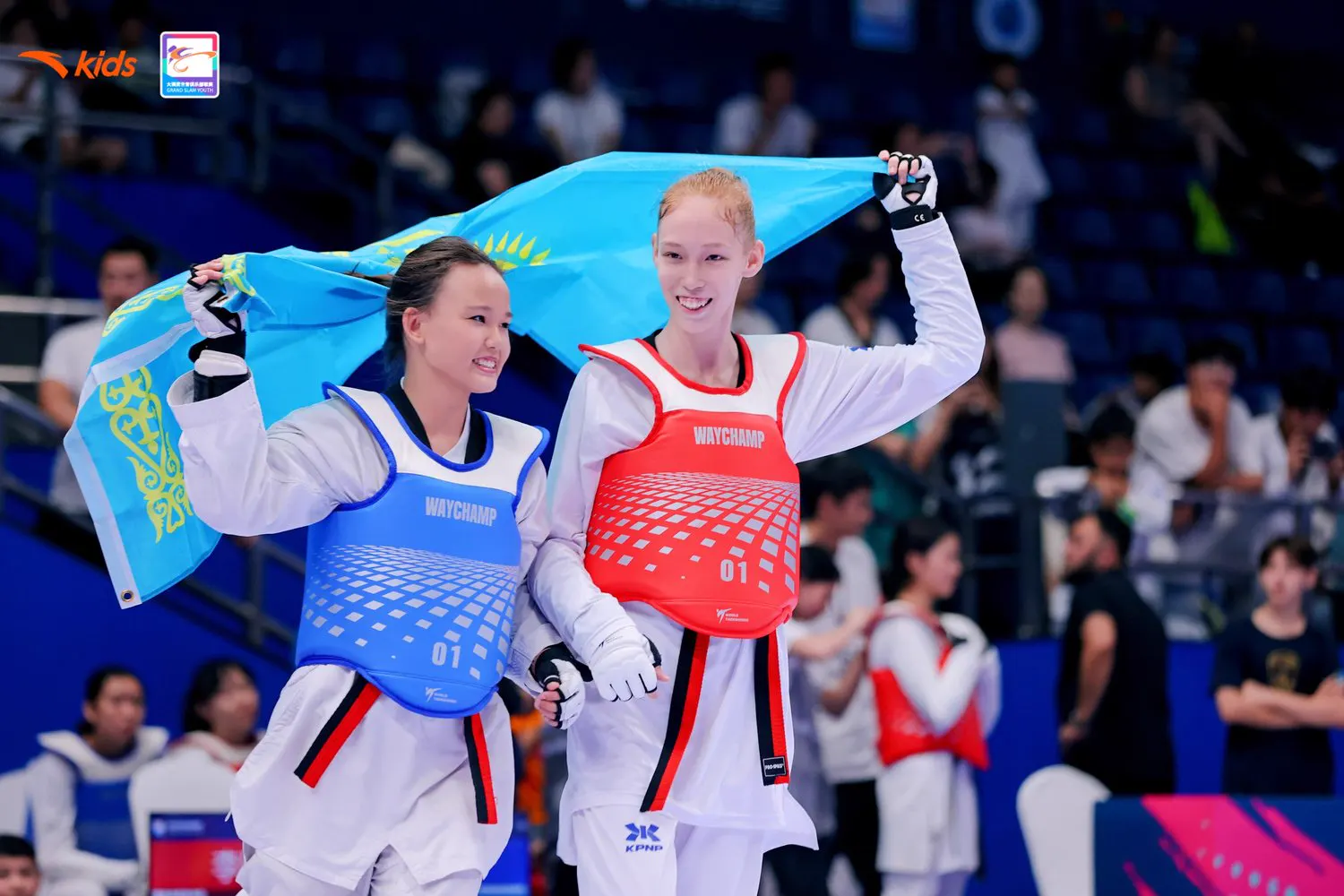 Two athletes in WayChamp chest protectors celebrating with a flag